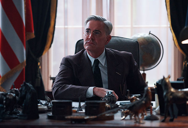 Photo of a man sitting at a desk Photo of a man sitting at a desk